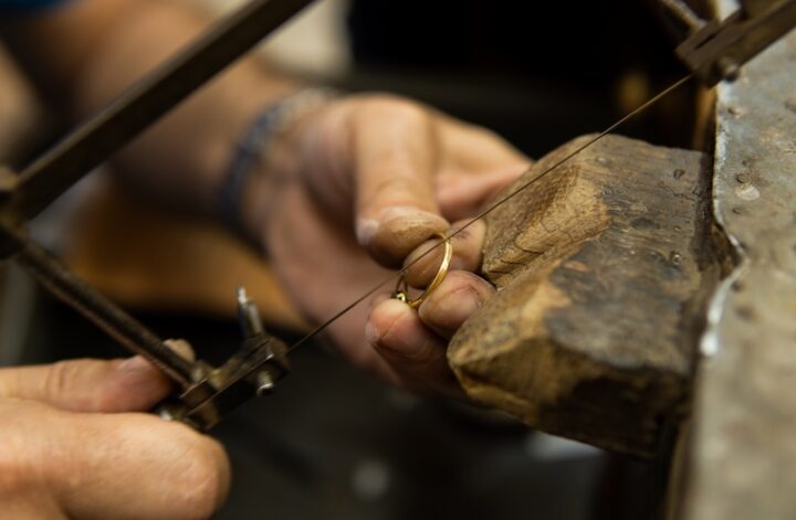 Guldsmed som filar en ring